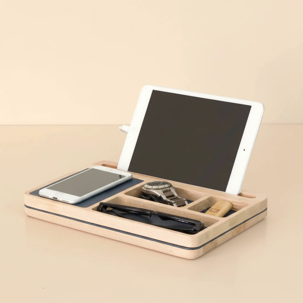 A natural wood desk organizer with a tablet, smartphone, watch, pen, and USB drive, professionally lit with soft shadows on a light background.