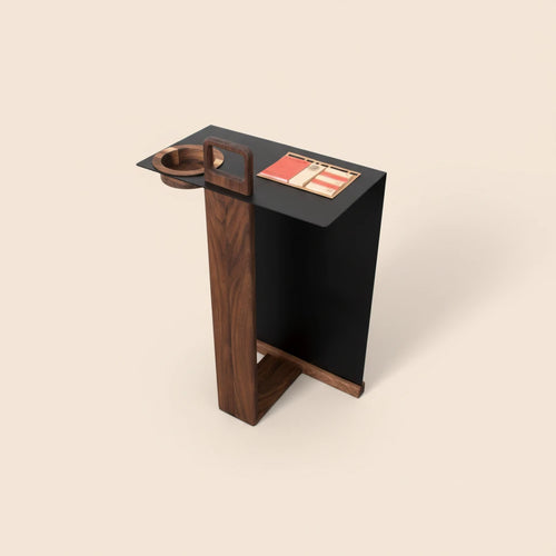 A luxury walnut side table with a black top and a built-in wooden coaster, presented on a clean #fceadb solid background with soft studio lighting.