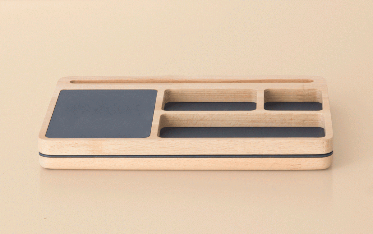 Natural wood desk organiser with black inset panels viewed from the front