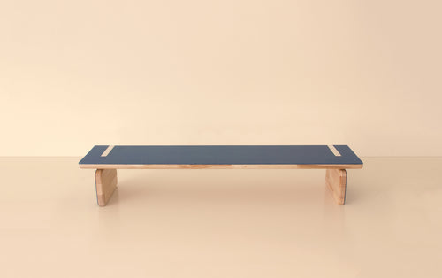 Front view of elegant natural wood bench with blue top and sturdy curved wooden legs